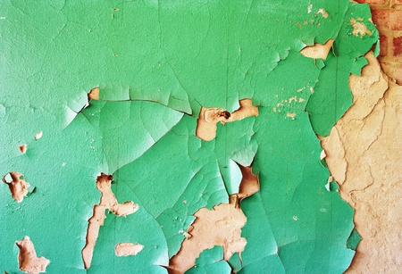 green weathered painted wall with cracked paintの写真素材