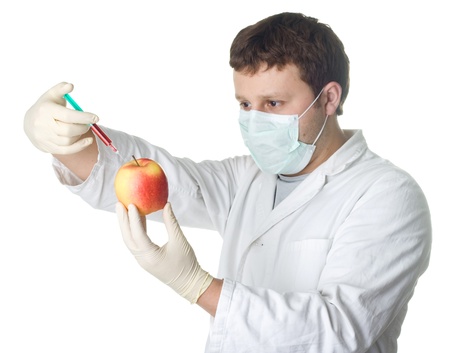 scientist injecting chemicals into appleの写真素材