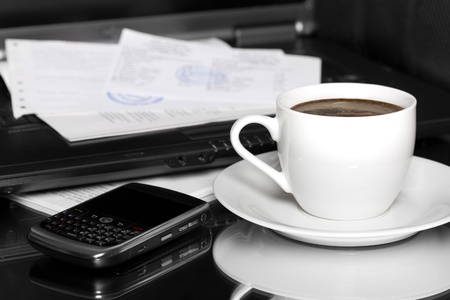 coffee at work with bills and cellphoneの写真素材