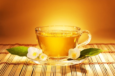 jasmine tea in soft warm evening light with fresh jasmine leaves and flowers の写真素材