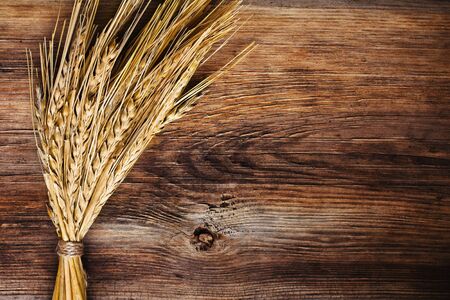 bunch of wheat ears on wood backgroundの写真素材