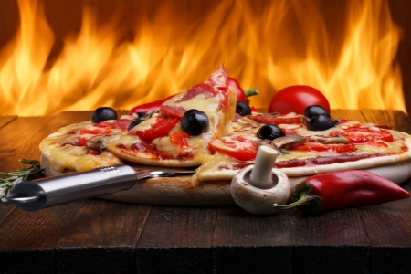 Hot pizza with oven fire on backgroundの写真素材