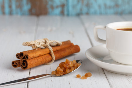 Coffee with caramel sugar and cinnamon on wooden table