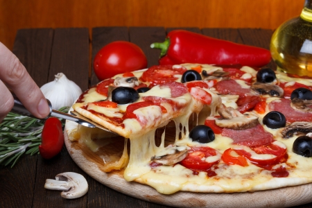 hot fresh pizza with melting cheese on lifterの写真素材