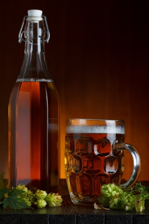 Beer still-life with fresh green hop on rustic wooden tableの写真素材