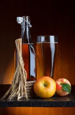 apple cider glass and bottle with apples and wheat still lifeの写真素材