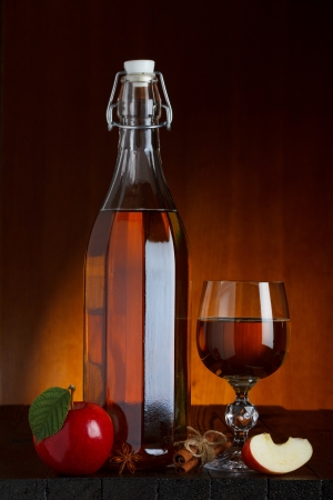Cider bottle and glass with apple, cinnamon and anise starの写真素材