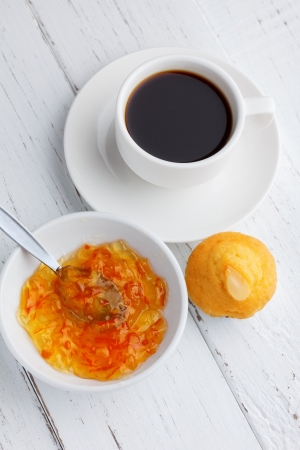 Cupcake with jam and coffee on wooden tableの写真素材