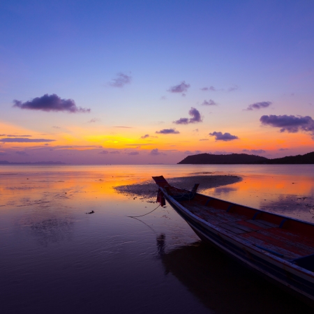 Sunset over sea with small wooden boat, Thailandの写真素材