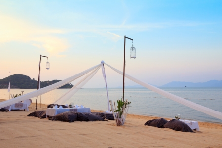 Romantic dinner setting on tropical beach at sunsetの写真素材