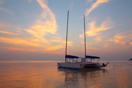 Catamaran on tropical beach at sunsetの写真素材