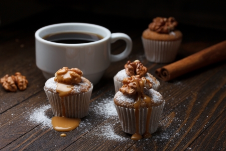 Cupcake with nuts and caramel on old wooden tableの写真素材