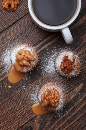 Cupcake with nuts and caramel on old wooden tableの写真素材