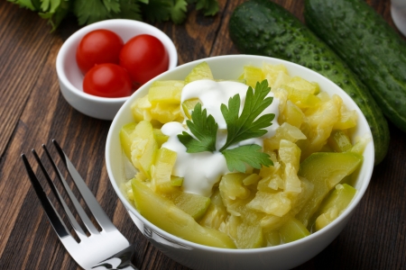 Bowl of prepared zucchini on wooden tableの写真素材
