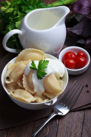 Meat dumplings with sour cream, traditional pelmeni or varenyky dishの写真素材