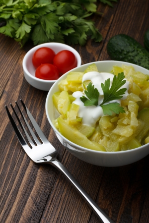 Bowl of prepared zucchini on wooden tableの写真素材