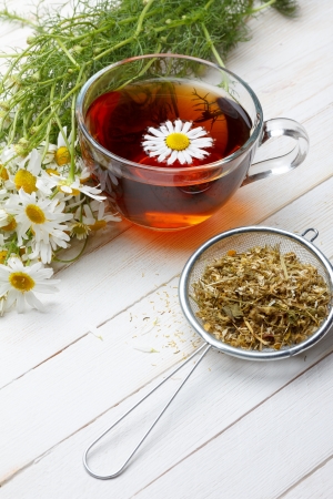 Dried chamomile and tea on wooden tableの写真素材
