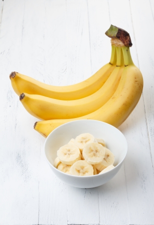 Sliced banana in bowl on wooden tableの写真素材