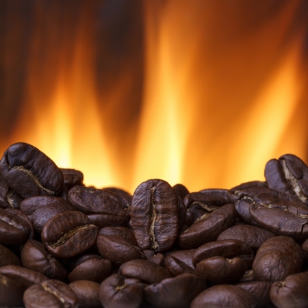 Coffee beans roasting with fire on backgroundの写真素材