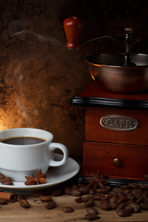 Cup of hot coffee with grinder and spices  on wooden table still lifeの写真素材