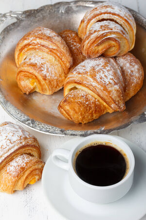 Coffee with fresh croissants on wooden table still lifeの写真素材