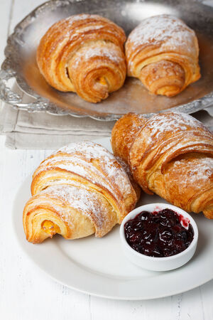 Fresh croissants with jam and sugar powderの写真素材