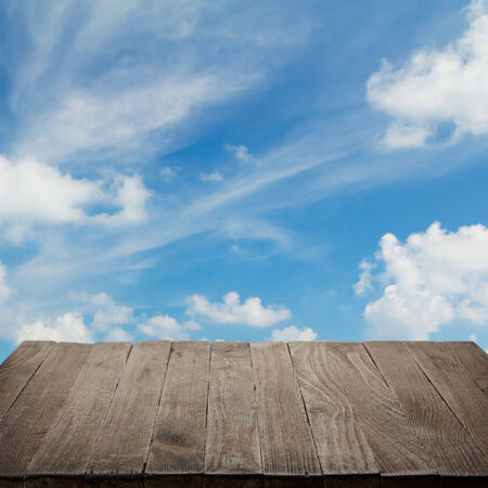 Empty wooden table with blue sky on background, blank place for productの写真素材