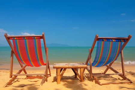 Two beach chairs on tropical shoreの写真素材