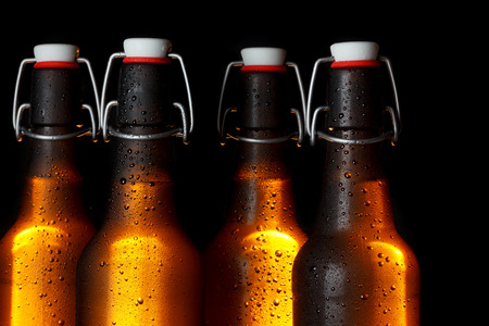 Golden glowing beer bottles on dark の写真素材