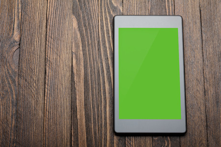 Tablet with blank screen on wooden tableの写真素材