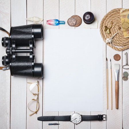 White blank paper sheet with lot of different creative stuff around it on wooden tableの写真素材