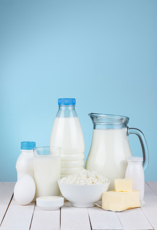 Dairy products assortment on wooden table, blue background, copy spaceの写真素材