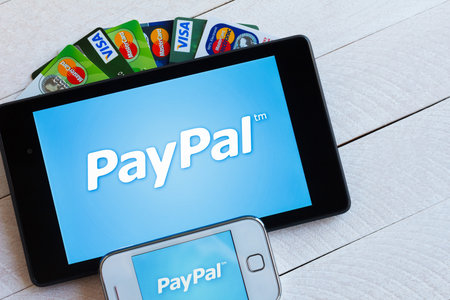 KIEV, UKRAINE - March 29: PayPal payment system logo on tablet and smarphone with plastic payment cards, Visa and MasterCard, in Kiev, Ukraine, on March 29, 2014.のeditorial素材