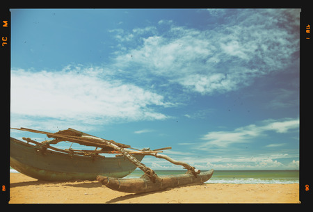 Small wooden fishing boat on tropical beach, retro film stylizedの写真素材