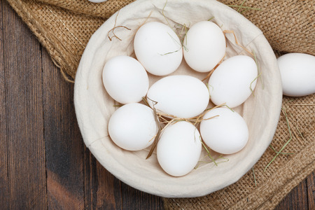 Eggs in a bowl on wooden tableの写真素材
