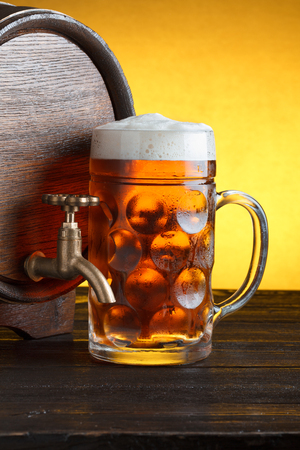 Vintage beer barrel with huge beer glass on wooden table still life close upの写真素材