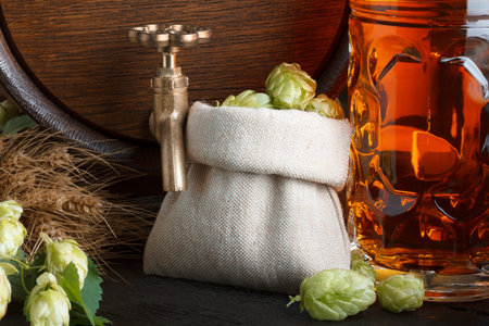 Beer barrel with hops, wheat and beer glass close-up