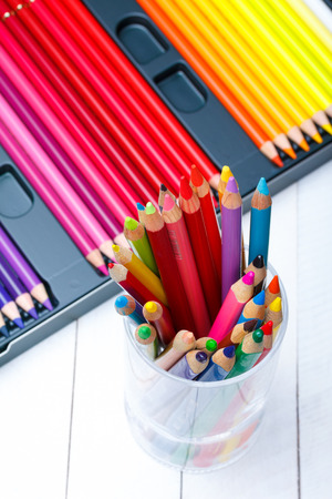 Multi colored pencils in jar on wooden tableの写真素材