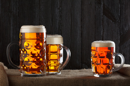 Beer glasses on table with burlap cloth, dark wooden backgroundの写真素材