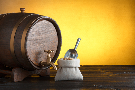Beer barrel with a bag of beer barley with scoop on wooden table with copy-spaceの写真素材