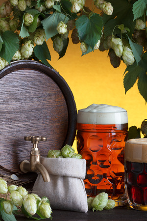 Beer barrel with beer glass, fresh hops and wheat still-lifeの写真素材