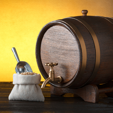 Beer barrel with a bag of beer barley with scoop on wooden table with copy-spaceの写真素材