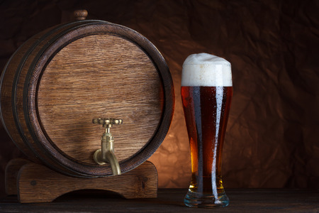 Beer barrel with beer glass on wooden table dark still-lifeの写真素材