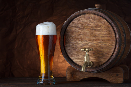 Beer barrel with beer glass on wooden table dark still-lifeの写真素材