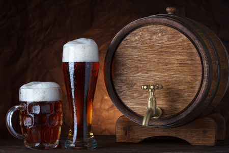Beer barrel with two beer glasses on wooden table dark still-lifeの写真素材