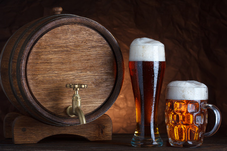 Beer barrel with two beer glasses on wooden table dark still-lifeの写真素材