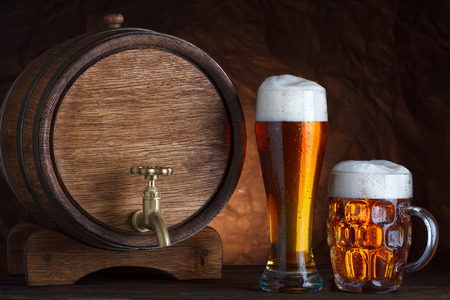 Beer barrel with two beer glasses on wooden table dark still-lifeの写真素材
