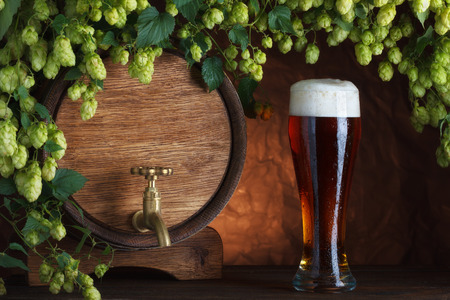Beer glass and beer barrel with fresh hops cones still-lifeの写真素材
