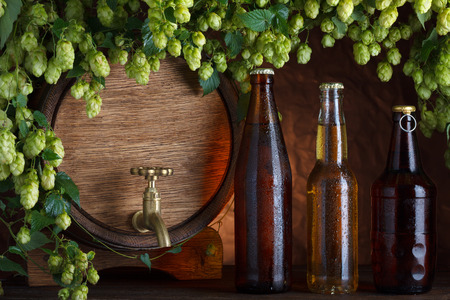 Beer bottles with beer barrel and fresh hops frame still-lifeの写真素材