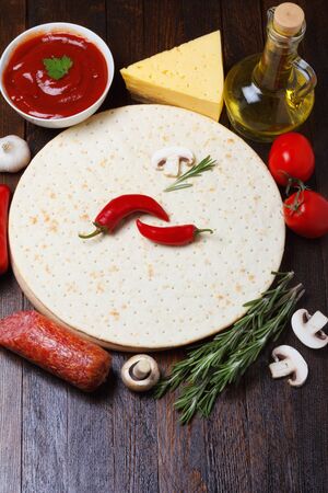 Pizza dough with different ingredients for cookingの写真素材